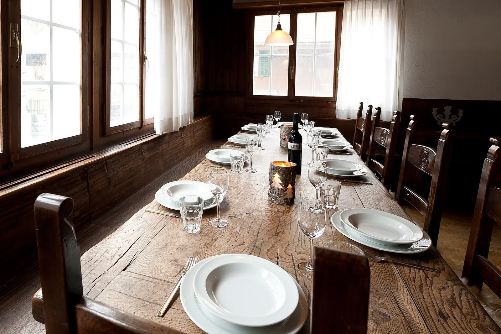 Langer Holztisch im Speisesaal des Hauses, eingedeckt fuer die Gruppe