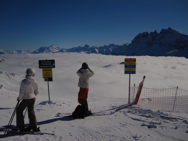 2000 Portes du Soleil - Les Crosets: Zwei Personen in Skikleidung an den Pistenschildern, dahinter das Panorama der Dents du Midi