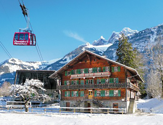 2011 Portes du Soleil - Champery: Gondel einer Bergbahn über einem Chalet mit bemalten Fensterläden