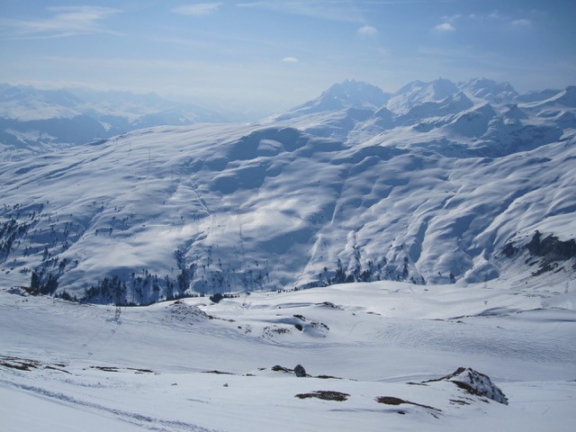 2012 Laax: Hochnebel über einer weiten Schneeflaeche, dahinter Bergketten