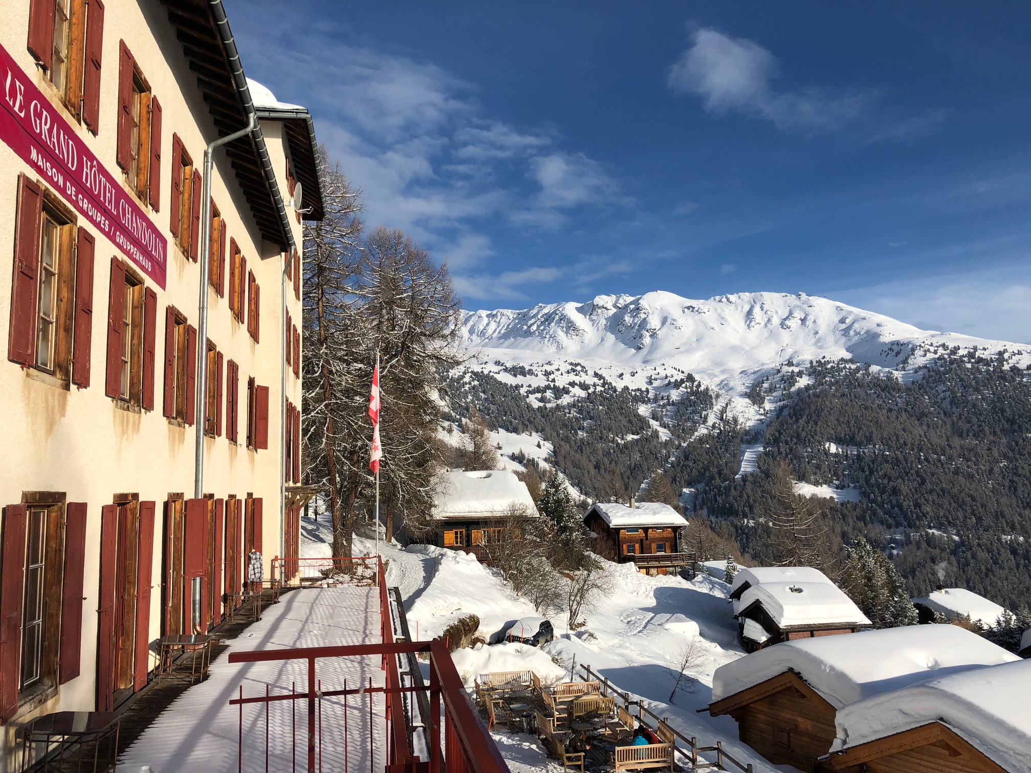 2018 Chandolin - Val d'Anniviers: Gelbes Haus mit roten Fensterläden am Hang, Blick hinunter ins Tal
