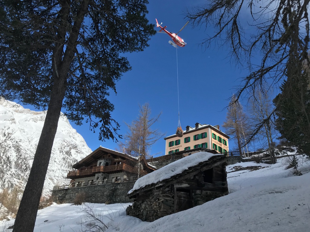 2019 Zermatt: Alte Walliser Holzhäuser und Stadel im Schnee, darüber die Seile der Bergbahn